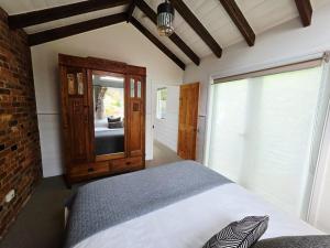a bedroom with a large bed and a mirror at Cascade Cottage Circa 1840 in West Hobart