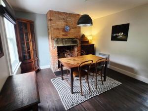 a dining room with a table and a fireplace at Cascade Cottage Circa 1840 in West Hobart
