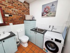 a bathroom with a sink and a washing machine at Cascade Cottage Circa 1840 in West Hobart +17 photos