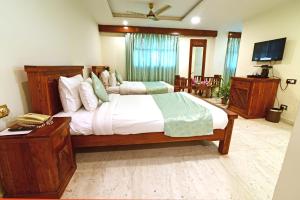 a bedroom with a large bed and a television at Lilypool - The Heritage Jalmahal in Jaipur