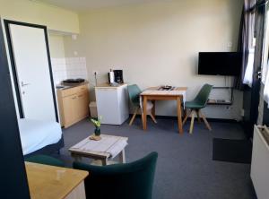 a room with a table and chairs and a kitchen at Motel Paradiso in Bad-Nieuweschans +29 photos