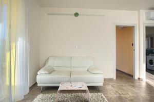 a living room with a white couch and a stool at Iris - Costadoro Holiday Home in Imperia