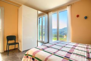 a bedroom with a bed and a chair and a window at Iris - Costadoro Holiday Home in Imperia