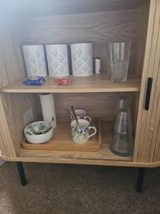 a wooden shelf with bowls and cups on it at Shalom, in Saundersfoot, near the sea in Saundersfoot +88 photos