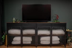 a black dresser with a flat screen tv on top at BDSM Play Apartments in Vilnius