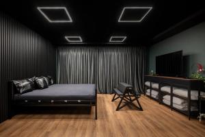 a black room with a bed and a television at BDSM Play Apartments in Vilnius