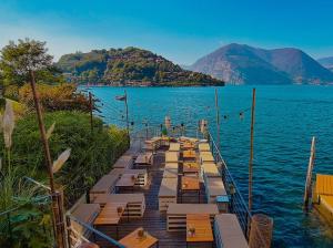 a dock with tables and chairs on the water at Casa Marì by Holiday World in Sulzano
