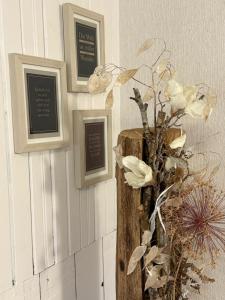 a vase with flowers on a wall with pictures at Haus Bergverliebt in Sebnitz