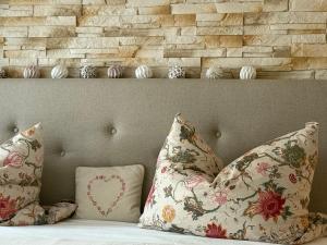 a bed with two pillows and a brick wall at Haus Bergverliebt in Sebnitz