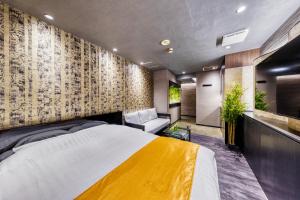 a bedroom with a large bed with a yellow blanket at HOTEL ATLANTIS IKUTAMA -Adult Only in Osaka