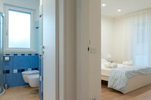 a bedroom with a bed and a toilet and a window at Brezza marina in Mola di Bari +65 photos