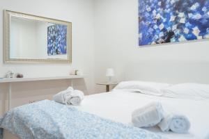 a white bedroom with two towels on a bed at Brezza marina in Mola di Bari