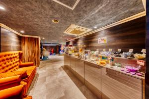 a restaurant with orange chairs and a counter with food at HOTEL ATLANTIS IKUTAMA -Adult Only in Osaka +9 photos