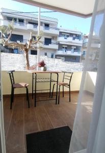 a table and chairs on a balcony with a building at Sfendamos Residence Kavala in Kavála +2 photos