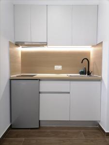 a kitchen with white cabinets and a sink at Sfendamos Residence Kavala in Kavála