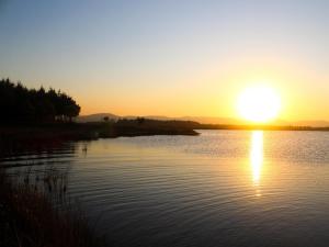 a sunset on a lake with the sun setting at Shiloh Lodges Tweefontein in Mooiriver +6 photos