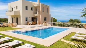a villa with a swimming pool in front of a house at Villa Victoria - A Private Family Gem in Gállos
