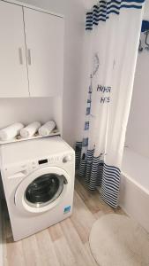 a white laundry room with a washing machine at Blue Pearl Molos in Mólos