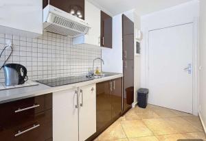a kitchen with white cabinets and a sink at Proche de Monaco appartement devant piscine in Beausoleil