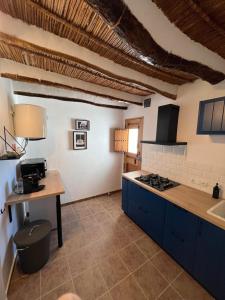 a kitchen with blue cabinets and a counter top at Cortijo de las Piedras in Lubrín