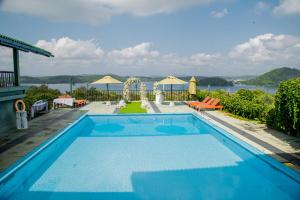 ein Schwimmbecken mit Blick auf das Wasser in der Unterkunft Lavendish Lake Giritale - Former Giritale Hotel in Polonnaruwa