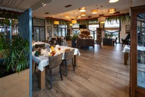 a restaurant with wooden floors and tables and chairs at Hotel Crystal in Pećinci