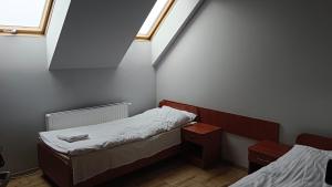 a small room with two beds and two windows at Hostel RAV in Tomaszów Mazowiecki +6 photos