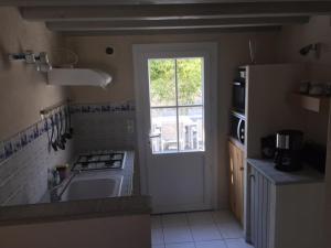 a kitchen with a sink and a stove and a window at la GRIERE in La Tranche-sur-Mer +10 photos