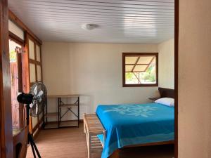 a bedroom with a blue bed and a window at Hakamanu Lodge in Tikehau +47 photos