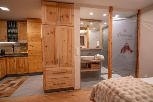 a bedroom with a bathroom with a sink and a mirror at Apart Alpin in Heiligenblut