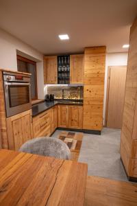 a large kitchen with wooden cabinets and a table at Apart Alpin in Heiligenblut