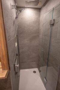 a shower with a glass door in a bathroom at Apart Alpin in Heiligenblut +3 photos