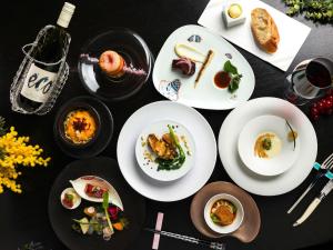 a table with plates of food and a bottle of wine at Executive Suite SUIREI in Jozankei
