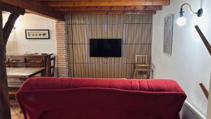 a living room with a red couch and a tv at Jolie Gîte dans les Pyrénées in Boutx