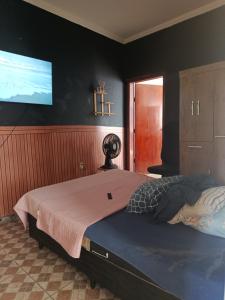 a bedroom with a large bed with a tv on the wall at Hospedaria e alojamento da Taty in Tatuí