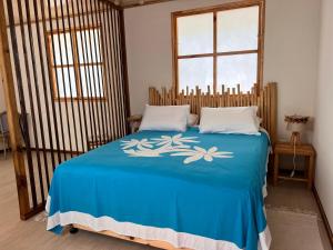 a bedroom with a bed with a blue blanket at Hakamanu Lodge in Tikehau