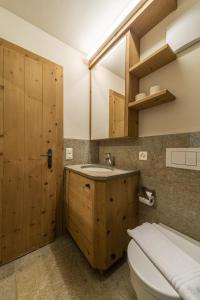 a bathroom with a sink and a toilet and a mirror at Chesa Diala - Zuoz in Zuoz +49 photos