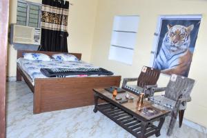 a bedroom with a bed and two chairs and a table at Sarla Resort in Sawāi Mādhopur