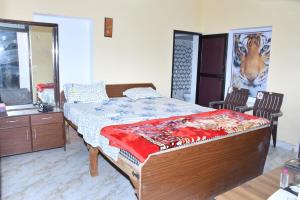 a bedroom with a bed and a painting of a giraffe at Sarla Resort in Sawāi Mādhopur
