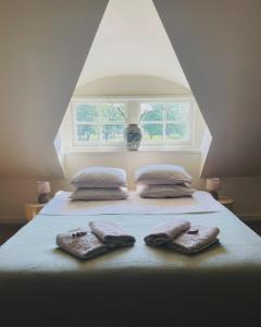 a bed with two towels on it with a window at WetterLoft - Luxe appartement met aanlegsteiger en terras in Terherne