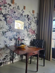 a dining room table with a floral wallpaper at De Citadel - de Weide in Markelo