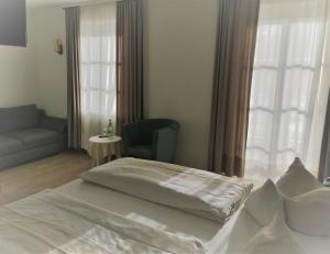 a bedroom with a bed and a chair and a window at Landhotel Steffen in Lieser