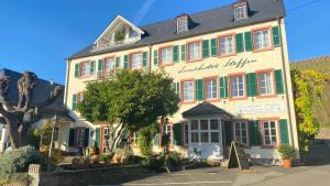 a large building with green and red shutters at Landhotel Steffen in Lieser