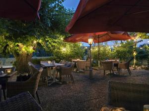 a restaurant with tables and chairs and an umbrella at Landhotel Steffen in Lieser +18 photos