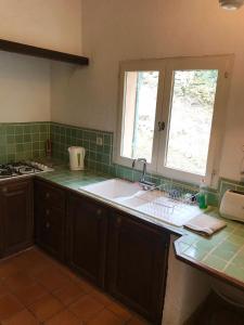 a kitchen with a sink and a window at La licorne in Serriera +13 photos