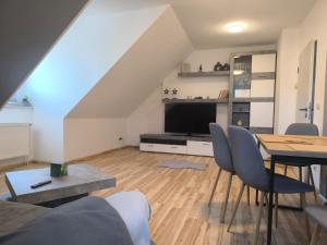 a living room with a table and a television at Ruhige Ferienwohnung NB in Neubrandenburg