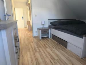a bedroom with a bed and a wooden floor at Ruhige Ferienwohnung NB in Neubrandenburg