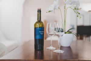 a bottle of wine and two glasses on a table at Domus Gallipoli by Casa di Marco in Gallipoli