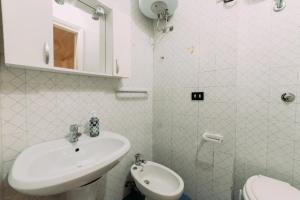 a white bathroom with a sink and a toilet at Domus Gallipoli by Casa di Marco in Gallipoli +9 photos