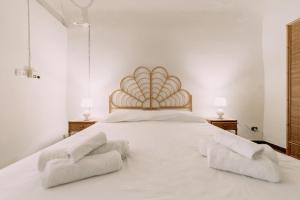 a bedroom with a large white bed with two towels on it at Domus Gallipoli by Casa di Marco in Gallipoli